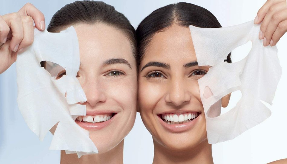 שתי נשים מחייכות ומסירות חצי ממסכת טישו