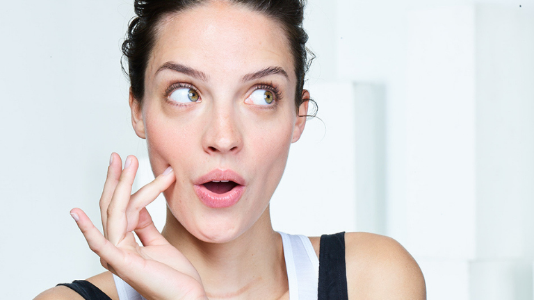 אישה לוחצת עם אצבע על הלחי קטן