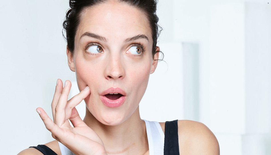 אישה לוחצת עם אצבע על הלחי גדול