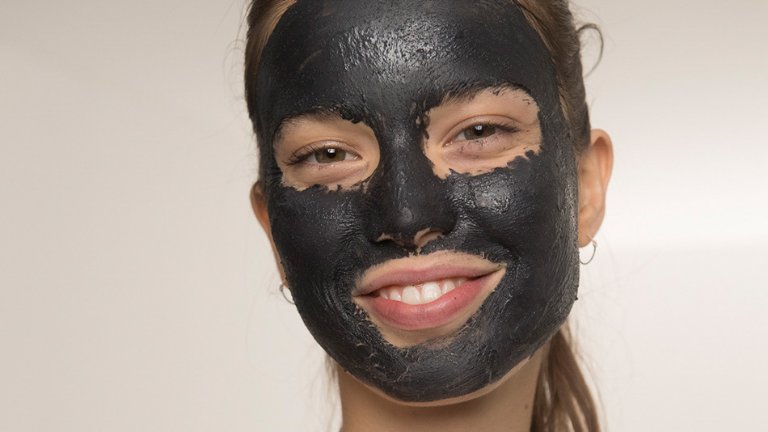 אישה עם קרם שחור על הפנים בינוני