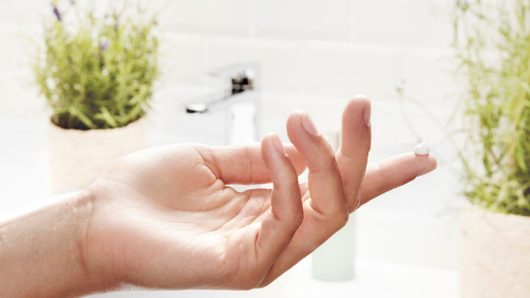 יד נושאת טיפה של קרם לבן בינוני