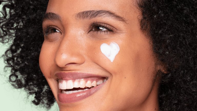 אישה עם קרם לבן בצורת לב על הפנים בינוני