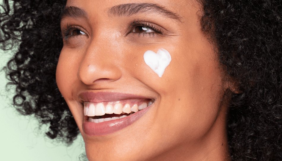 אישה עם קרם לבן בצורת לב על הפנים גדול