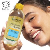 דוגמנית מציגה בקבוק מים מיסלריים ויטמין סי של גרנייה